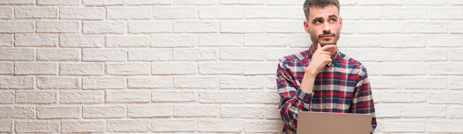 A person in a plaid shirt with a computer 