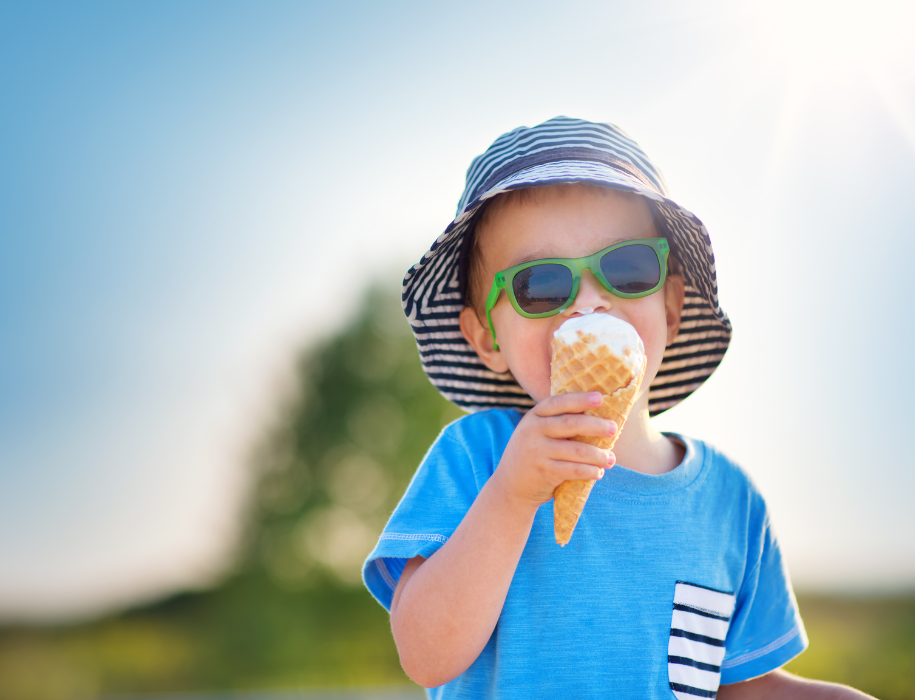 Happy child eating ice cream outdoors in summer