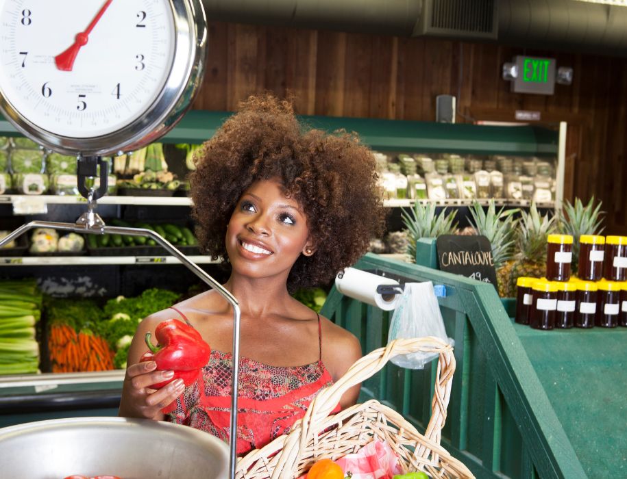 Woman in grocery store weighing produce