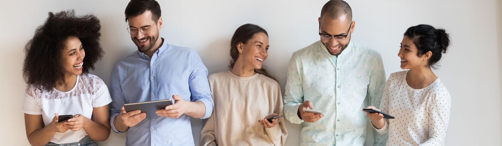 group holding mobile devices and smiling at each other