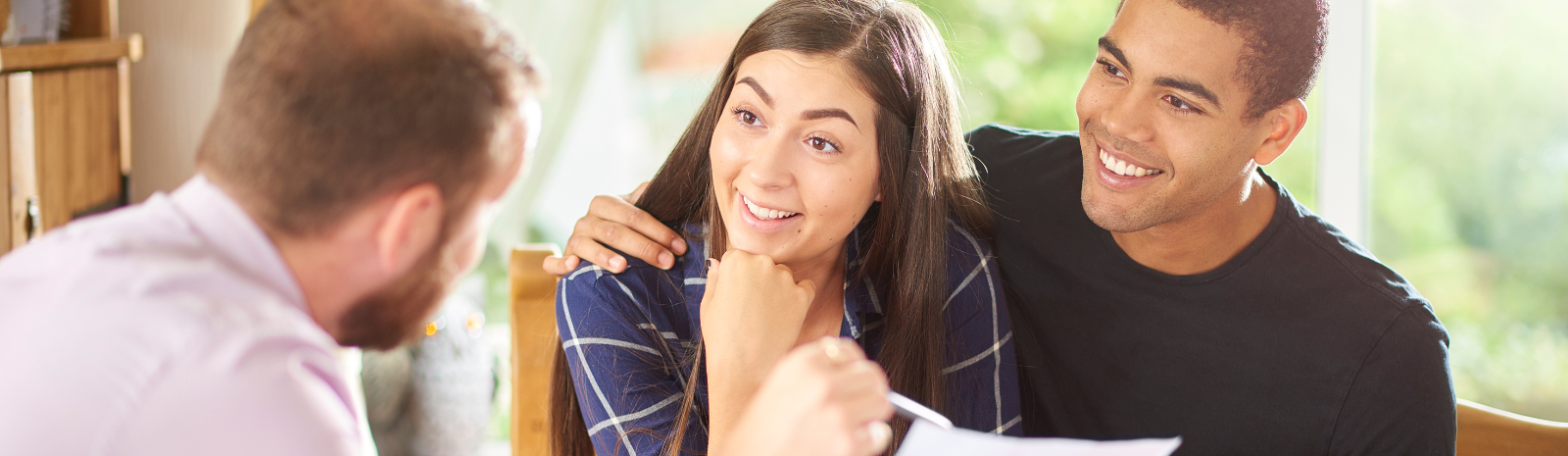 Couple reviewing mortgage preapproval documents with a loan officer at a table—discussing home financing options, interest rates, and loan eligibility during the home buying process