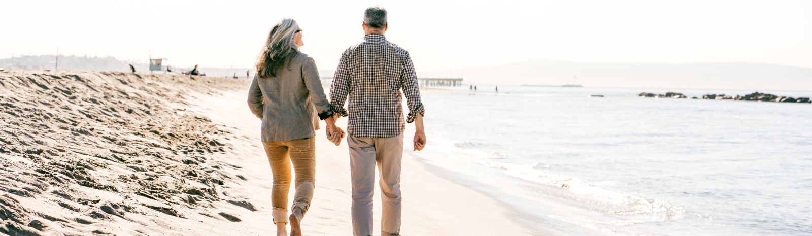 Couple walking down beach holding hands