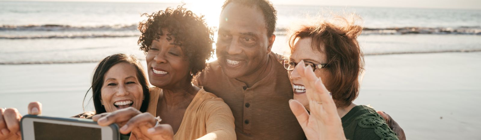 People posing for a selfie on a beach