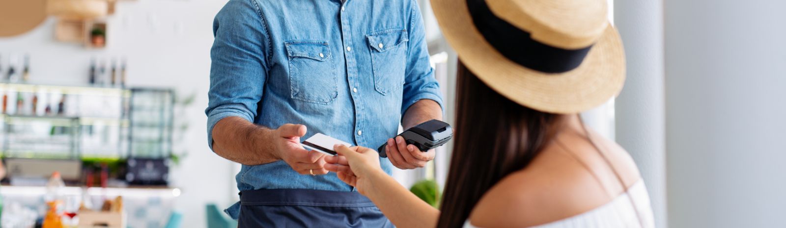 girl in hat handing credit card to cashier