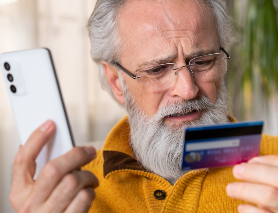 A person holding a credit card and phone.