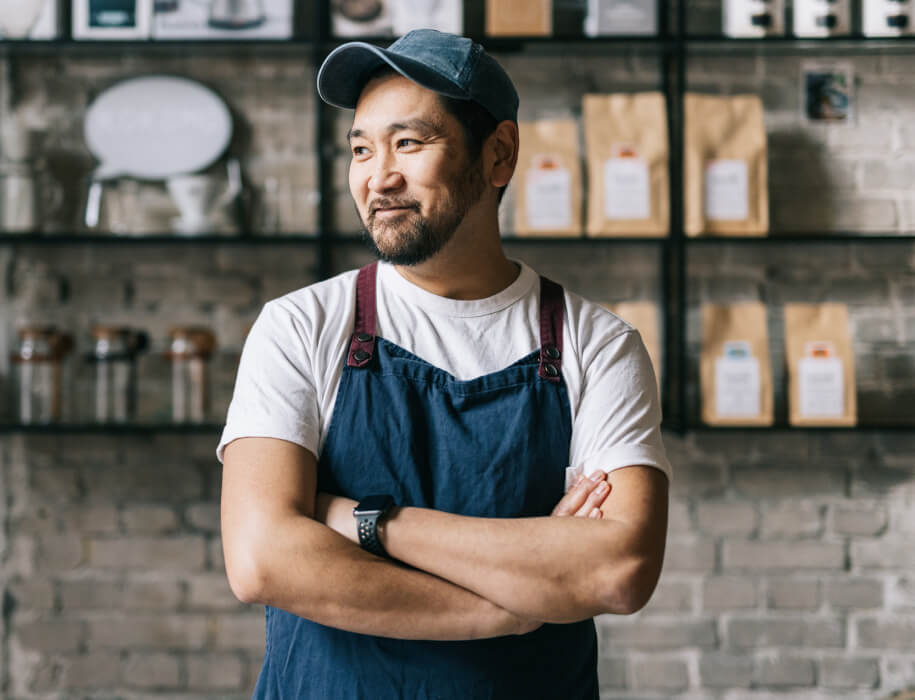 Man in apron standing in a coffee shop